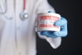 doctor hand holding plastic dental teeth model on table Royalty Free Stock Photo