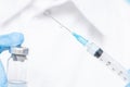 Doctor hand holding syringe and vaccine in blue gloves white coat. Disease injection concept Royalty Free Stock Photo