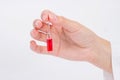 Doctor hand holds glass ampoule with red medicine liquid2