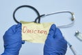 Doctor hand holds a piece of rumpled paper with Omicron text