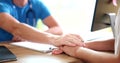 Doctor hand man calms female patient in clinic