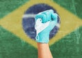 Doctor hand in medical glove with a mask in front of flag of the Brazil.
