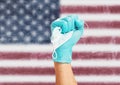 Doctor hand in glove with a mask in front of flag of the United States of America.