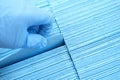 Doctor hand in rubber gloves pulling out sterile disposable napkin from packaging closeup