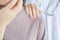 Doctor hand on shoulder of unhappy female patient comforting