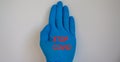 Doctor hand in sterile blue gloves. Stop covid inscription