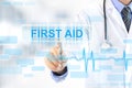 Doctor hand touching FIRST AID sign on virtual screen Royalty Free Stock Photo