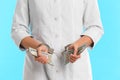 Doctor in handcuffs with bribe on blue background. Corrupted medicine Royalty Free Stock Photo
