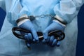 Doctor in handcuffs holding a stethoscope, concept of medical corruption, bribery Royalty Free Stock Photo