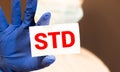 Doctor hands in blue gloves shows the word STD sexually transmitted disease. Medical concept Royalty Free Stock Photo