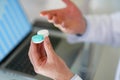 Male optometrist hands giving pair of contact lens in case to patient offering choice Royalty Free Stock Photo