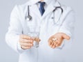 Doctor hands giving white pills and glass of water Royalty Free Stock Photo