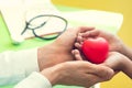 Doctor hands holding and giving red massage heart to patient lit Royalty Free Stock Photo