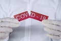 Doctor hands ripping Covid-19 text