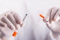 Doctor hands in rubber gloves holding open insulin syringe on white background Royalty Free Stock Photo