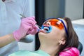 Doctor hands with tweezers inserts a cotton swab into her mouth