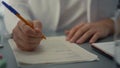 Doctor hands writing medical documents close up. Unknown medic filling journal.