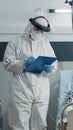 Doctor with hazmat suit doing checkup visit for aged woman Royalty Free Stock Photo