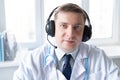 Doctor in headset speaks, talks to patient. Telehealth, telemedicine, online consultation, video call conference. Medical concept Royalty Free Stock Photo