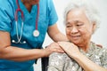 Doctor help Asian elderly woman disability patient sitting on wheelchair in hospital, medical concept