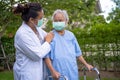 Doctor help and care Asian senior or elderly old lady woman use walker with strong health while walking at park in happy fresh Royalty Free Stock Photo