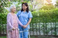 Doctor help and care Asian senior or elderly old lady woman use walker with strong health while walking at park in happy fresh Royalty Free Stock Photo