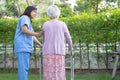 Doctor help and care Asian senior or elderly old lady woman use walker with strong health while walking at park in happy fresh Royalty Free Stock Photo