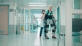 Doctor is helping a handicapped woman to move in the exosuit