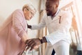 The doctor helps to get out of bed an elderly woman in a nursing home. Royalty Free Stock Photo