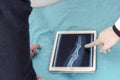 Doctor with his finger showing a x-ray in a tablet. Royalty Free Stock Photo