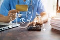Doctor hold credit cards, conduct financial transactions via tablets and data documents, put on the desk in the morning