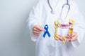 Doctor holding Blue ribbon with human Colon anatomy model. March Colorectal Cancer Awareness month, Colonic disease, Large