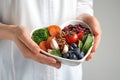 Doctor holding bowl with products for heart-healthy diet