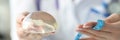 Doctor holding breast implant and measuring tape closeup Royalty Free Stock Photo