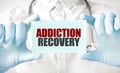 Doctor holding card in hands and pointing the word ADDICTION RECOVERY Royalty Free Stock Photo