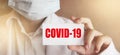 Doctor holding a card with text COVID-19 , medical healthcare concept