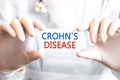 Doctor holding a card with text CROHNS DISEASE