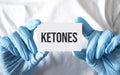 Doctor holding a card with text ketones, medical concept