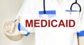 Doctor holding a card with text MEDICAID medical concept