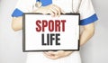 Doctor holding a card with text SPORT LIFE,medical concept