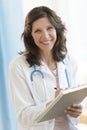 Doctor Holding Clipboard While Standing In Clinic Royalty Free Stock Photo