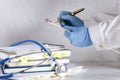 Doctor holding clipboard and writing a prescription, stack of documents and books, stethoscope on the white desk Royalty Free Stock Photo