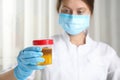 Doctor holding container with urine sample for analysis in laboratory Royalty Free Stock Photo