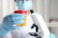 Doctor holding container with urine sample for analysis, focus on hand Royalty Free Stock Photo