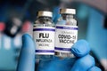 Doctor Holding Coronavirus vaccine bottles and Flu Shot vaccine for booster vaccination for new variants of Sars-cov-2 and Royalty Free Stock Photo