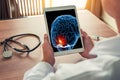 Doctor holding a digital tablet with x-ray of a brain with pain on the front. Migraine headache or trauma concept. Royalty Free Stock Photo