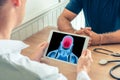 Doctor holding a digital tablet with x-ray of a brain of a patient. Brain cancer or headache prevention Royalty Free Stock Photo