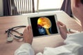 Doctor holding a digital tablet with x-ray of head and pain in the front of brain and neck. Migraine and headache concept Royalty Free Stock Photo