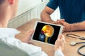 Doctor holding a digital tablet with x-ray of the head of the patient with pain on the front of the brain. Cancer headache concept Royalty Free Stock Photo
