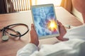 Doctor holding a digital tablet with x-ray of hips with pain on the right. Stethoscope and syringe on the desk